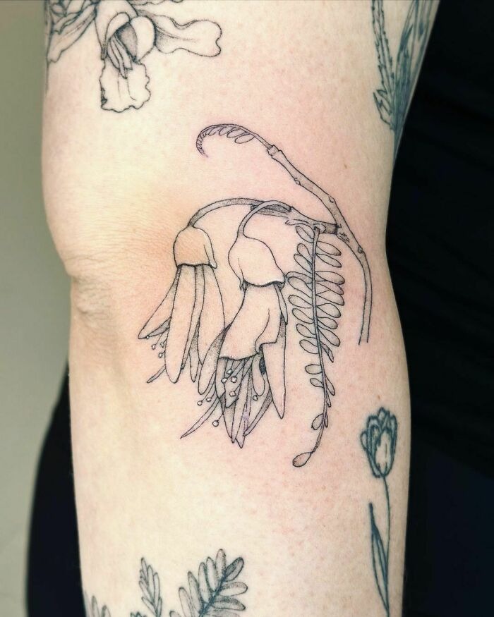 Delicate flower tattoo on arm showcasing intricate linework and botanical design.