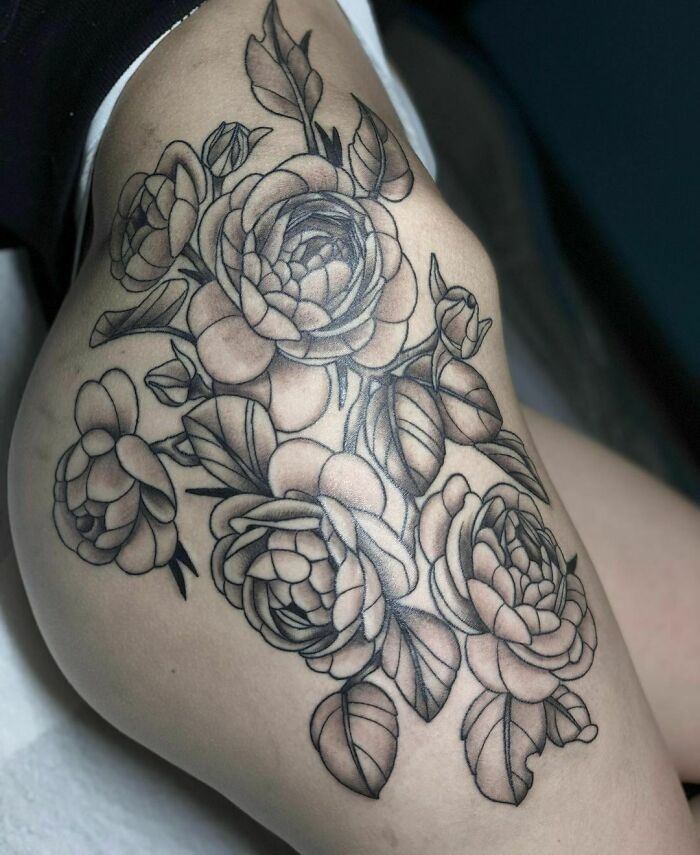 Floral tattoos with roses and leaves intricately inked on skin.